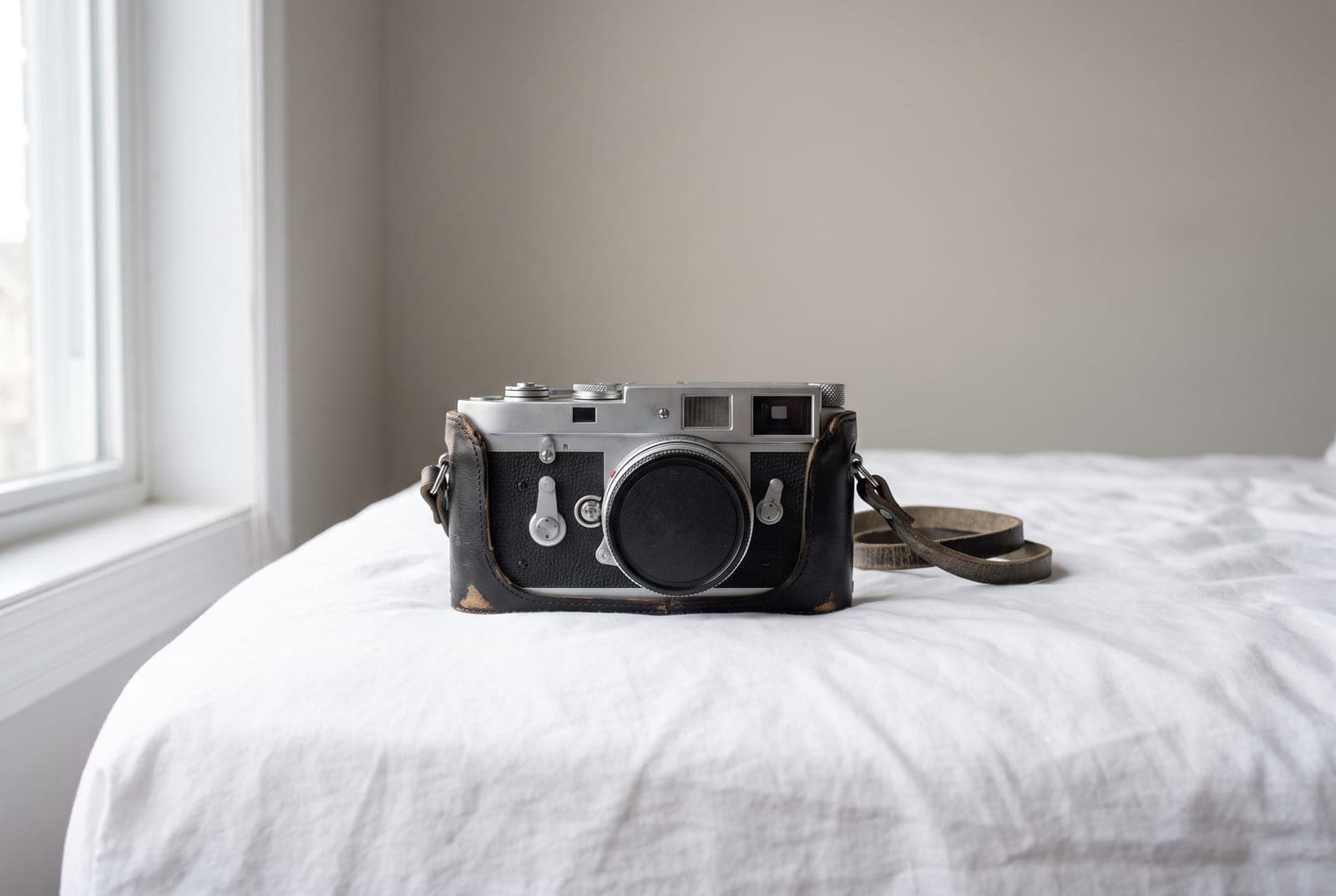 A vintage film camera on a plain white sheet in soft daylight, shot as the main photo of an eBay listing