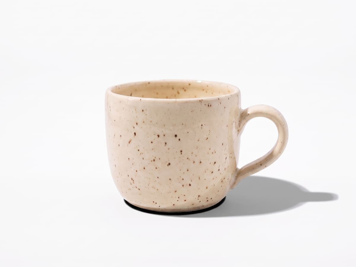 The same ceramic mug on white with a shadow cast to the lower right