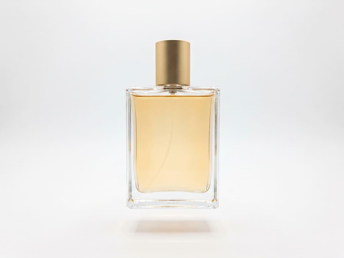 A glass perfume bottle on a plain white background
