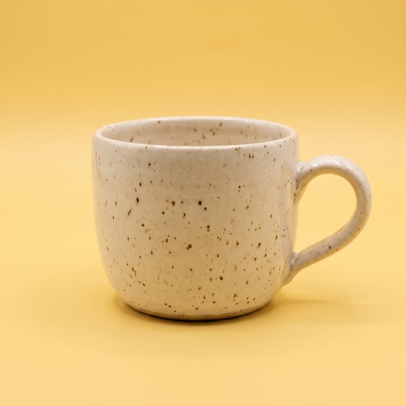 Dieselbe Tasse auf einem buttergelben Hintergrund