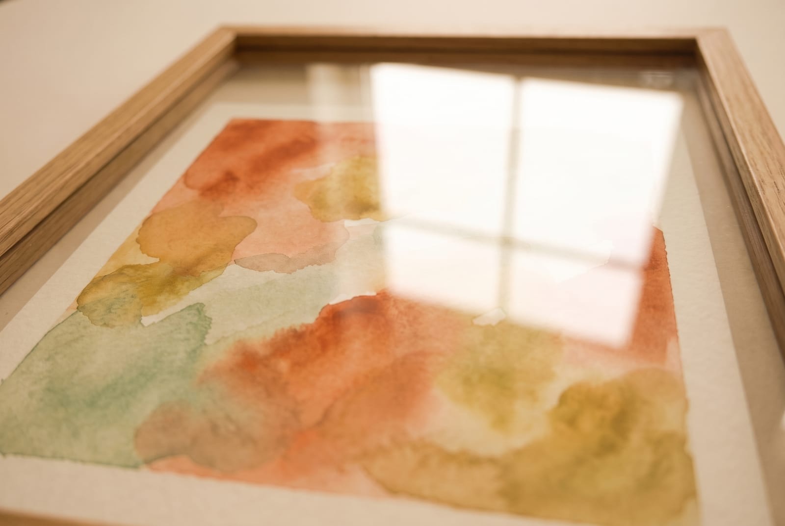 The same painting under glass, photographed from an angle with a window reflected across it